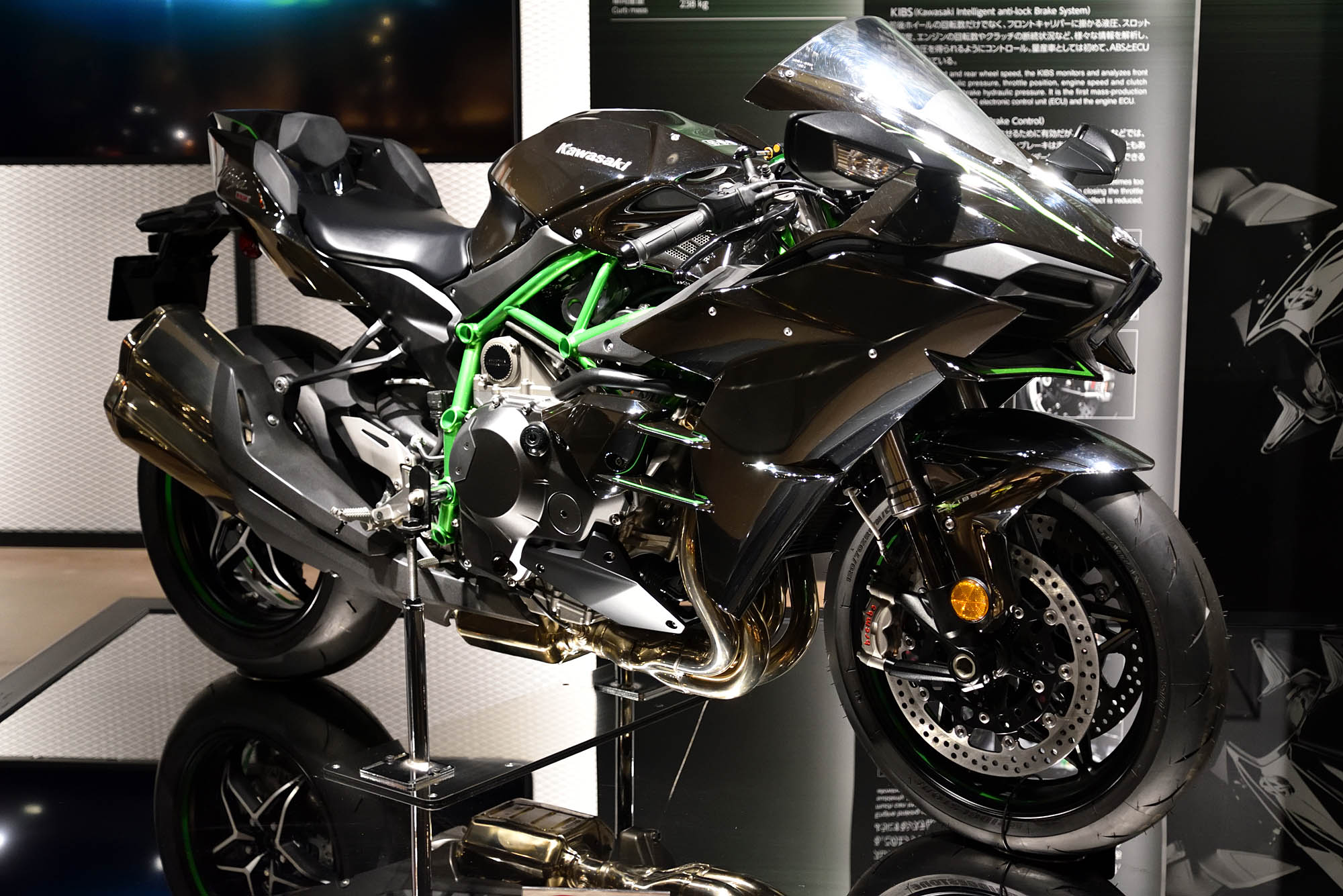 A 2015 Kawasaki Ninja H2 with black bodywork and a green frame on museum display
