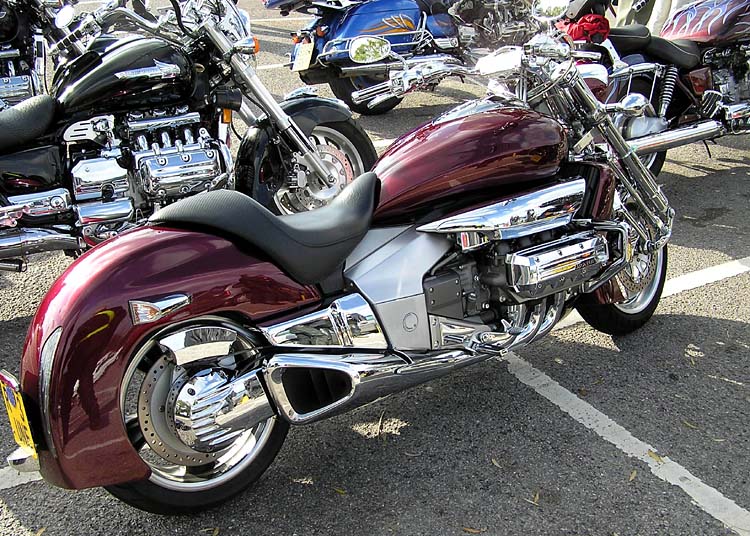 A dark red Honda Rune with a chrome six-cylinder engine and broad rear fender.