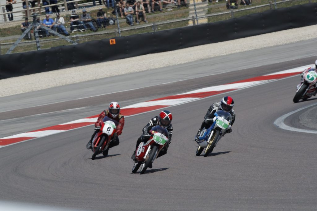 Classic motorcycles cornering at the 2018 Coupes Moto Légende event.