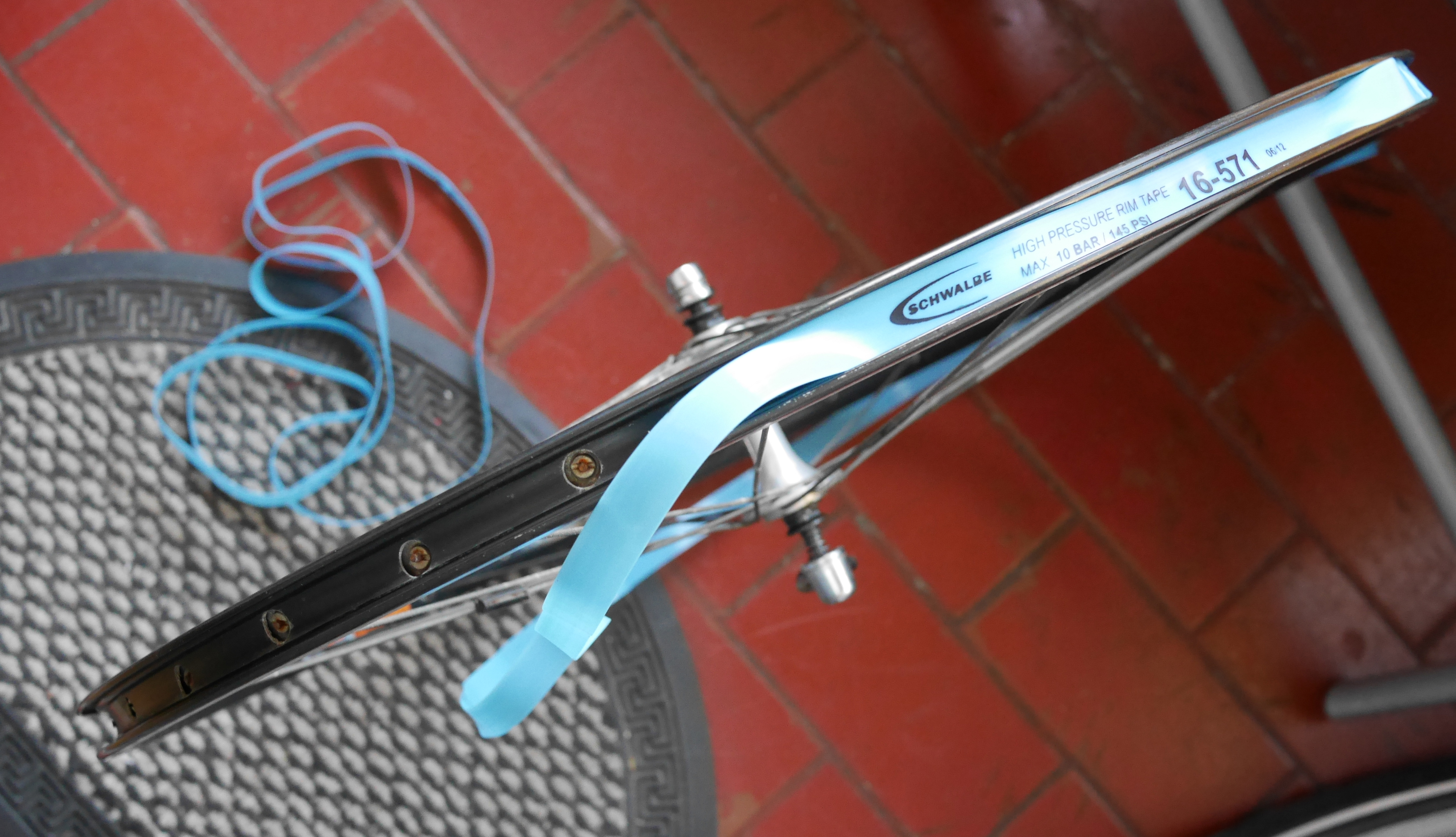 Fitting rim tape to a bicycle wheel with the tire removed.